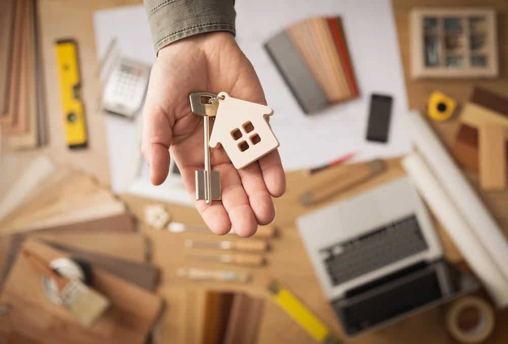 Hand holding a key with a house keychain